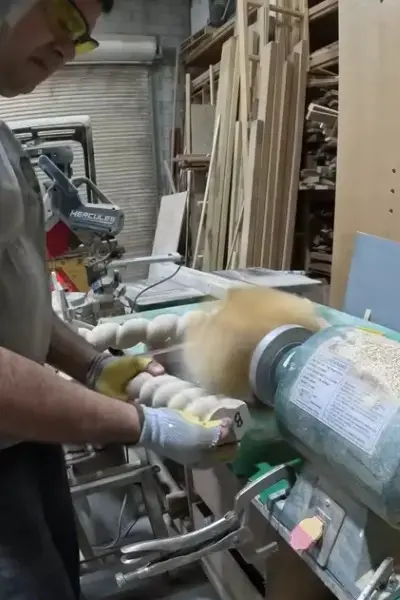 Sanding the barley twist legs with a flapper sander