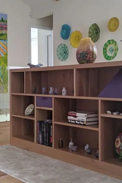 Low bookshelf with purple accent pieces