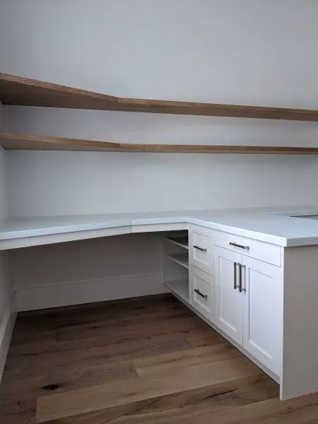 White office cabinetry with oak shelving