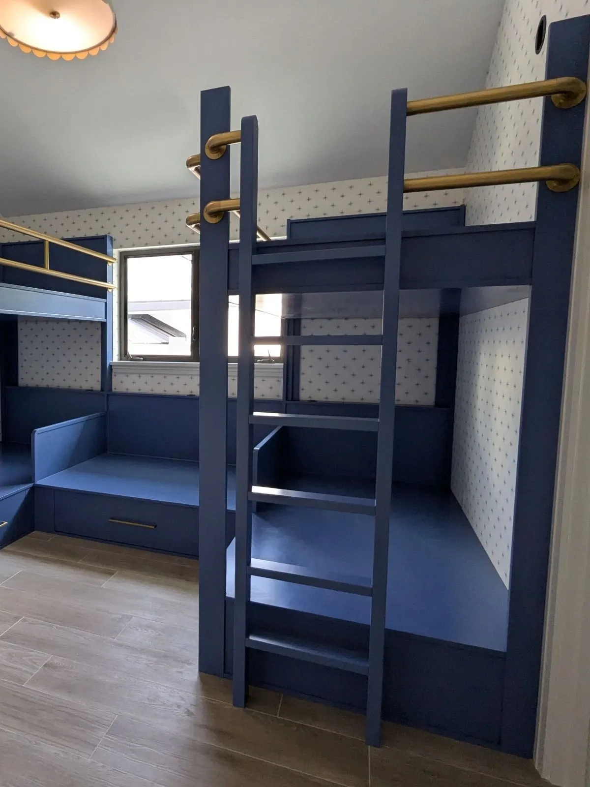 Bright blue bunk room with brass railings